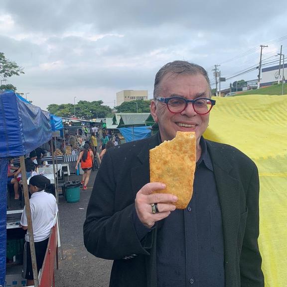 Walcyr Carrasco comendo pastel de feira