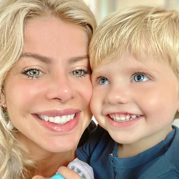 Ao lado do filho, Enrico, Karina Bacchi sorri para a câmera