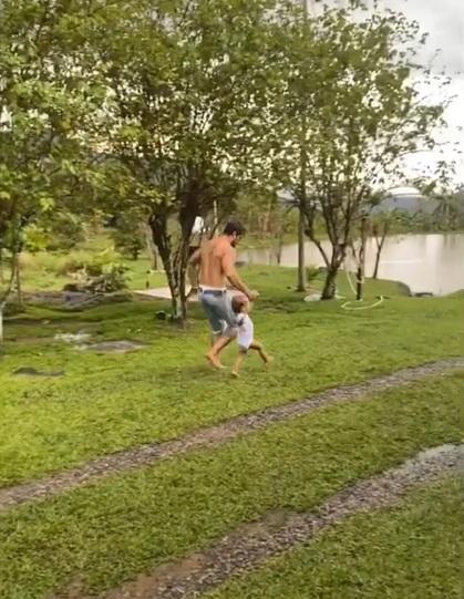 Rafael Cardoso toma banho de chuva com os filhos