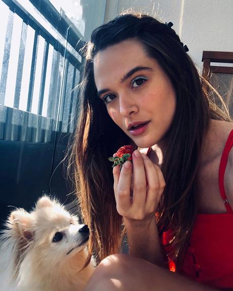 Juliana Paiva come morangos coladinha com seu cachorro 