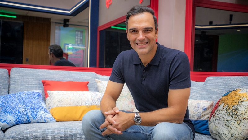 O apresentador Tadeu Schmidt na casa do BBB 23, sentado na sala - Foto: Divulgação/Globo