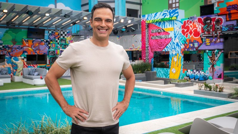 O apresentador Tadeu Schmidt na casa do BBB 23, posando de frente para a piscina - Foto: Divulgação/Globo