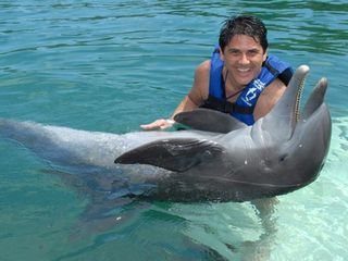 Cesar na água com um golfinho em Cancun, México