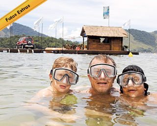 Pedro, Marcello e Diogo nadam no mar da Ilha de CARAS, com o Acqua Lounge Fiat ao fundo