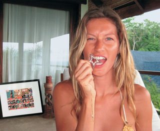 Na casa de praia em Malpais, Costa Rica, a modelo brinca com a jóia de brilhantes e rubis; ao fundo, as capas de CARAS.