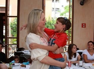 Adriana Colin segura no colo criança do GRAAC durante almoço na Pizzaria Esperanza - Divulgação