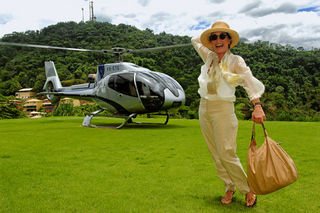 Regina se diverte com o vento após desembarcar do helicóptero da Helisolutions em Angra. No ar em Três Irmãs, garante que o tempo a deixa cada vez melhor. - Fotos: Cadu Pilotto; agradecimentos: Uluart; produção: Claudio Lobato