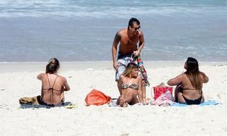 O ator Paulinho Vilhena conversa com Preta Gil e Carolina Dieckmann na praia da Reserva, no Rio de Janeiro - AgNews