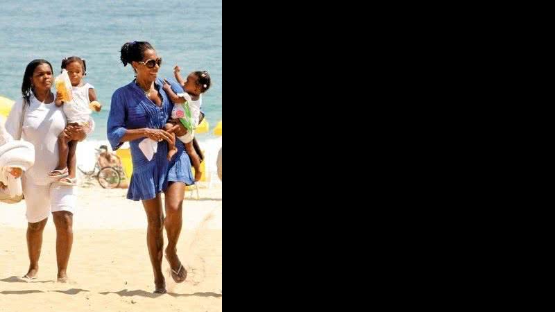 Ao lado da babá Lita, com Maria no colo, Glória Maria deixa a praia do Leblon fazendo graça para a caçula, Laura. - Wallace Barbosa/Ag. News