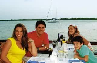 Elaine e Cesar, com Luma e Luigi Lorenzo, almoçam no píer de um restaurante caribenho. - FOTOS: ARQUIVO PESSOAL