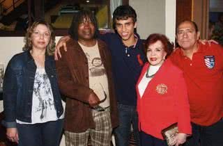 Em casa, Milton abraça Pedrinho cercado pelos pais do rapaz, Etiene e Nelson, e a cantora Lana Bittencourt, de vermelho.