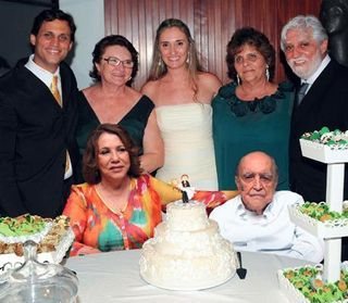 Diante do bolo, Vera e Oscar, ganham o carinho, em pé, dos noivos entre a mãe dela, Anna Rita, e os pais dele, Anna Elisa e Walter. - JOÃO MÁRIO NUNES