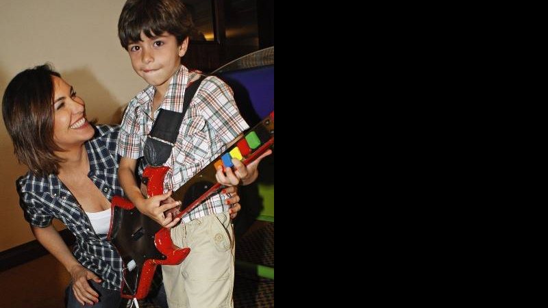 Orgulhosa, a jornalista brinca com o filho no Guitar Hero. - RODRIGO MINASSIAN