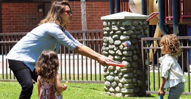 Grávida, ela joga frisbee com primogênita. - Splash