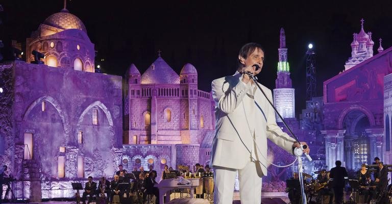 Roberto no palco, com reproduções dos sítios sagrados de Jerusalém. - Samuel Chaves