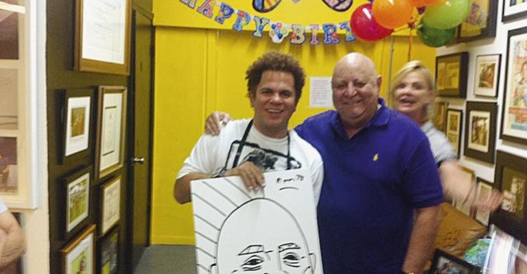 Romero Britto comemora 48 anos ao lado do amigo Luiz Schmidt, que completa 69 anos e ganha desenho de seu rosto assinado pelo artista, na galeria de Britto, em Miami.