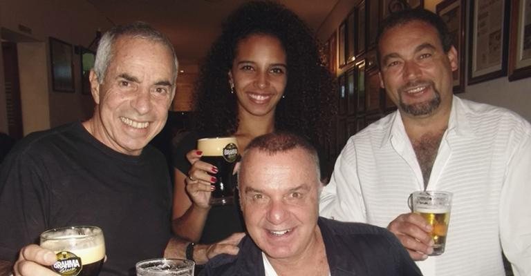 Em SP, Paulo Bauab, Bruna Rocha, Walter Camargo e Mario Almeida, sentado, brindam em bar.