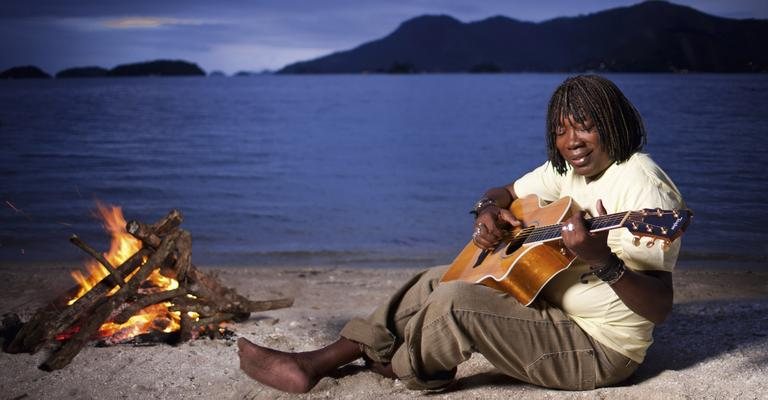 De violão em punho ao cair da noite na praia da Ilha, Milton canta na areia e relembra o primeiro violão que teve, com o qual aprendeu a tocar ainda na infância. - Murillo Constantino