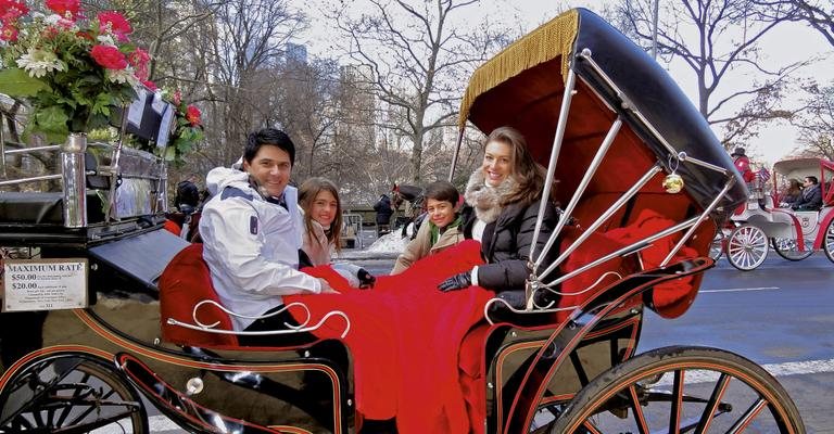 No Central Park, em NY, o casal Cesar Filho e Elaine Mickely faz passeio de charrete com os filhos, Luma e Luigi. As férias de 30 dias do clã é pautada por muitas brincadeiras.