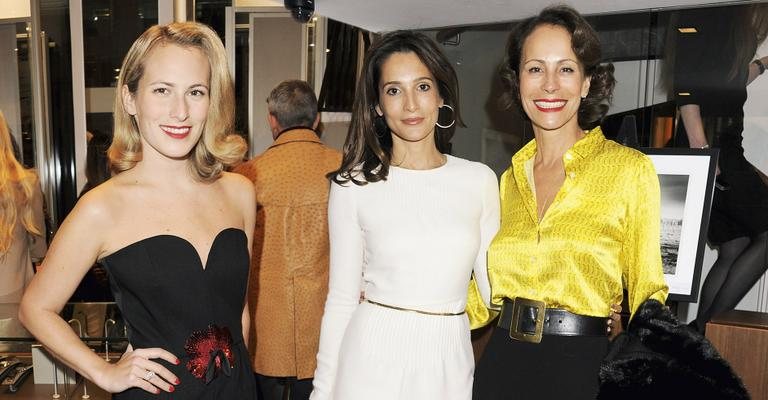 Elegante, a anfitriã é ladeada pela designer Charlotte Dellal e a mãe, a jet-setter Andrea Dellal, em sua primeira mostra fotográfica, Gauchos, em Londres. - Getty Images