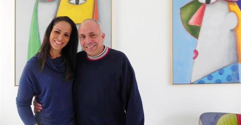 Karla Haidar Muller e o artista plástico Gustavo Rosa celebram parceria em que a empresa dela faz sacolas ecológicas com pinturas feitas por ele, na casa dele, em SP.