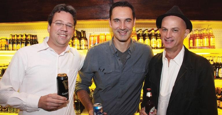 Mario Reuter é ladeado pelos amigos Daan de Kroon e Cássio Piccolo em seu aniversário, em bar de SP.