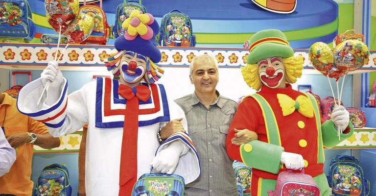 Os palhaços Patati e Patatá festejam com Roni Kabbani o lançamento de sua nova linha de mochilas e acessórios em feira de material escolar, SP. - -