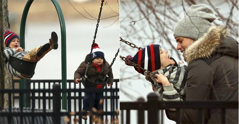 Em parque próximo à casa do clã em Boston, o astro do futebol americano abraça seu primogênito,
John. No detalhe, o garoto diverte-se com o irmão, Benjamin, no balanço. - Splash News