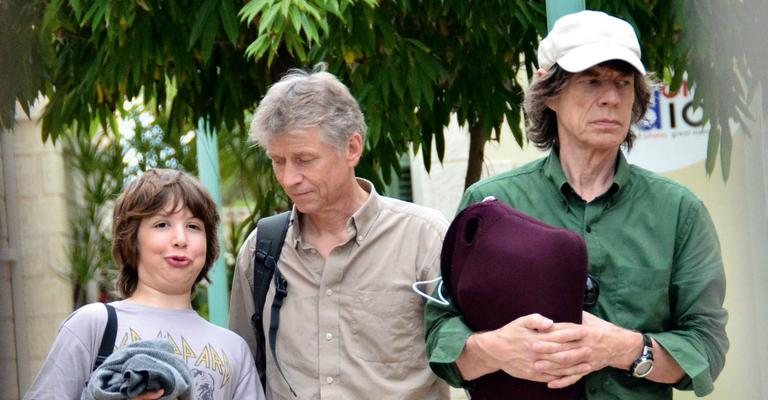 Ótimos companheiros de viagem, Mick, de boné, e o caçula chegam à ilha caribenha para dias de descanso. Em 2013, Mick e banda voltam à turnê. - Splash News