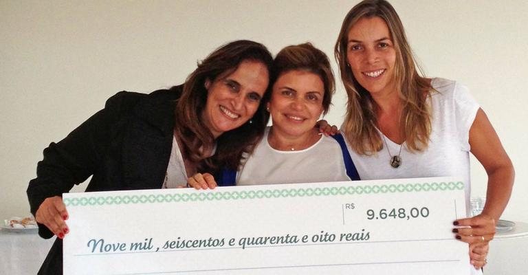 A sócia de rede de docerias Ivani Calarezi, ao centro, entrega donativo à instituição de Regina Helou e Regina Moraes Waib, em Cotia, SP. - -