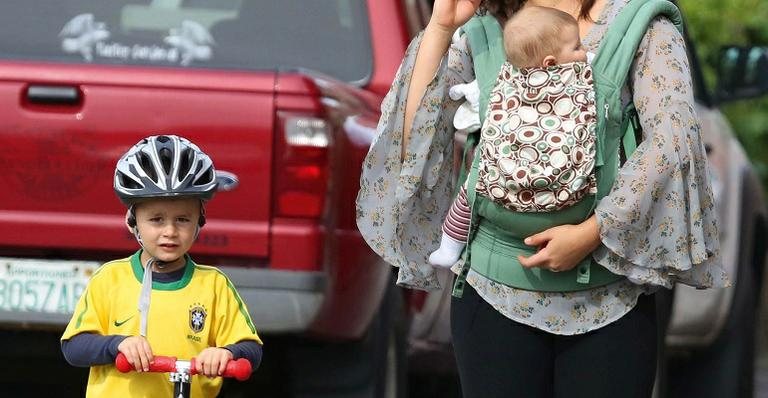 Observado pela babá, o primogênito de Gisele se diverte com o patinete, devidamente protegido. A caçula Vivian em caminhada no ‘canguru’ - Stickmann