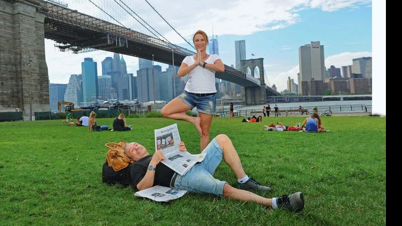 Diante da Brooklyn Bridge e às margens do Hudson, Marilene faz yoga e Stenio lê jornal local. - Jayme de Carvalho Jr.