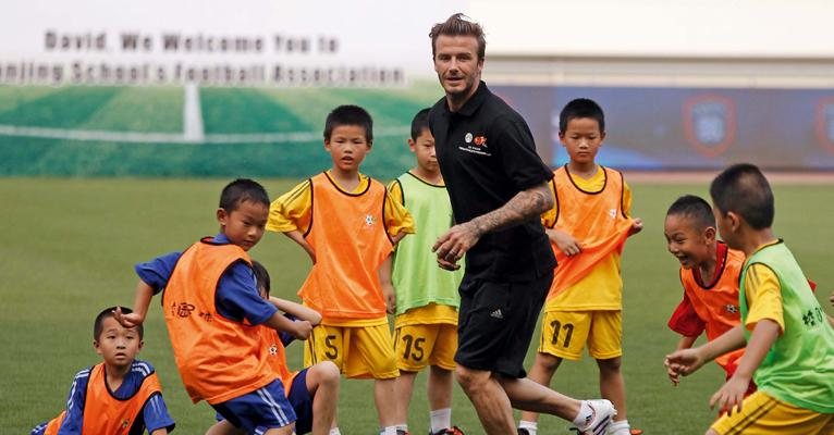 David Beckham bate-bola com chineses - Aly Dong/Reuters