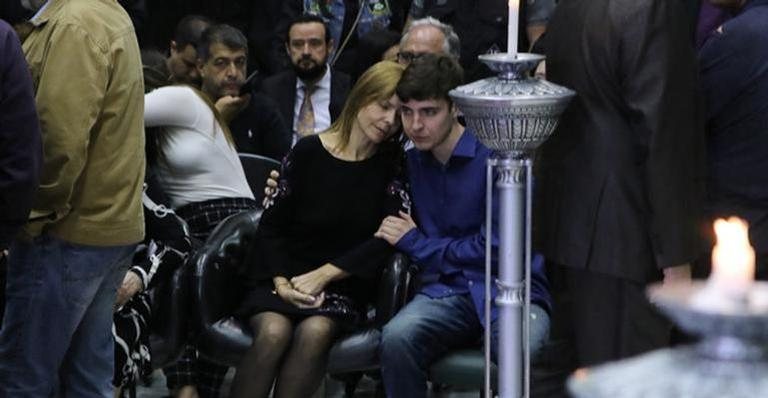 João Augusto é visto dando suporte à mãe em velório do pai. - Foto:Francisco Cepeda e Thiago Duran/AgNews