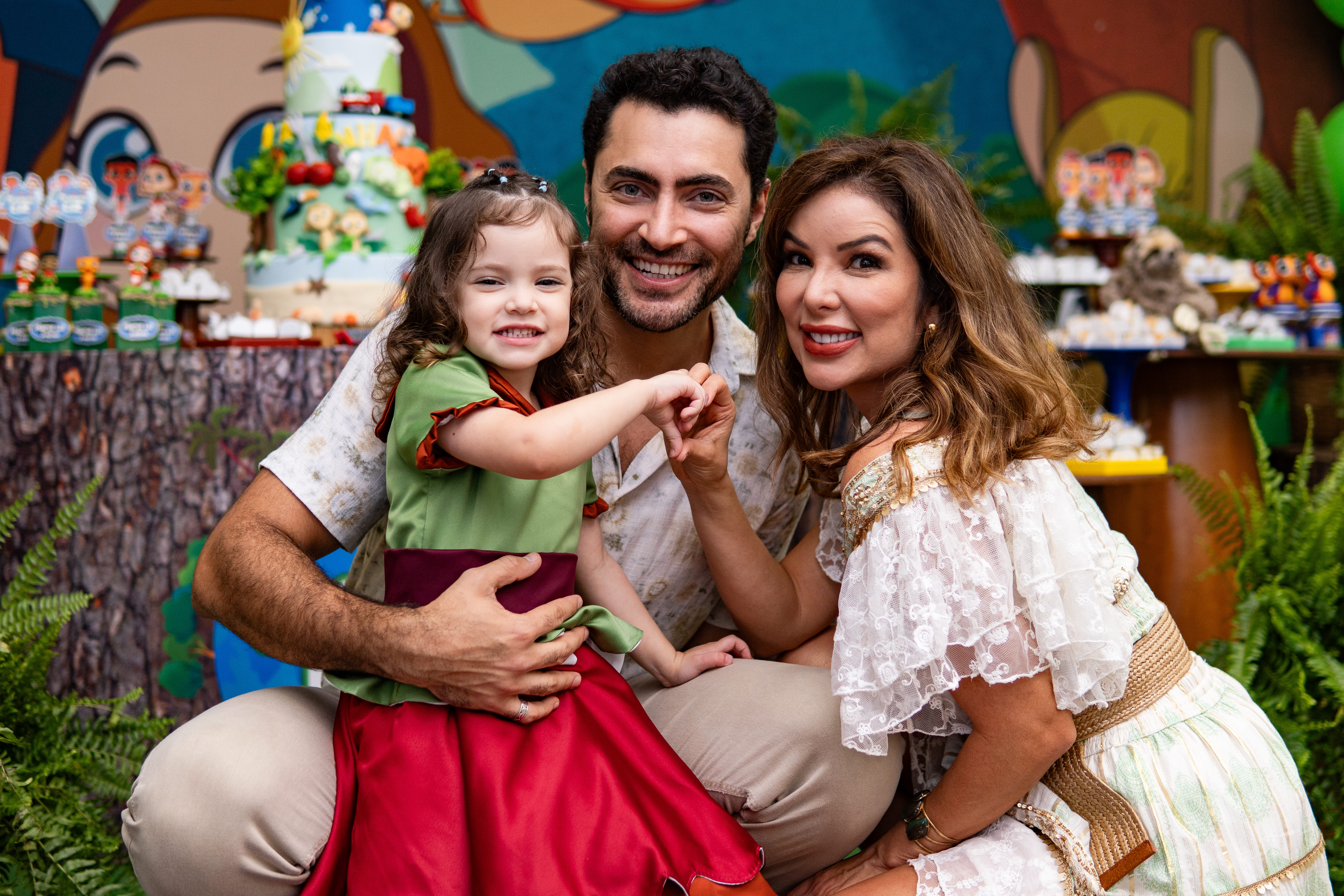 Carlo Porto e Liah Soares com a filha na frente da mesa de bolo