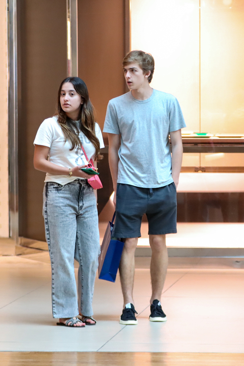 Os amigos passearam e levavam compras durante o tempo no shopping