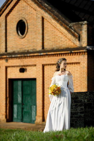 Vestido de musselina de seda com corselete de zibeline Marie Toscano; buquê de ranúnculo, frézia e rosa chá Monica Rezende Flores; jóias e adornos da cabeça Rosana Chinche