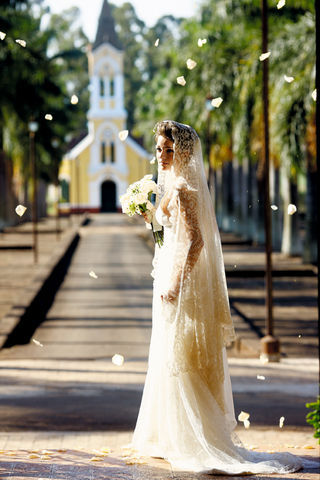 Vestido com renda-pétala que cobre as costas, faixa drapeada e saia em camadas de tule e renda, Ana Cristina Prates para Maria Cereja; buquê Studio Andrea Saladini