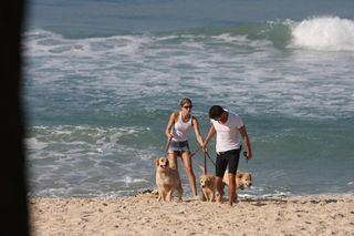 Grazi Massafera e Cauã Reymond brincam com os cães na Prainha, Rio