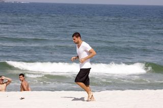 Cauã Reymond corre pela praia da Barra da Tijuca