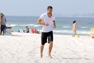 Cauã Reymond corre pela praia da Barra da Tijuca