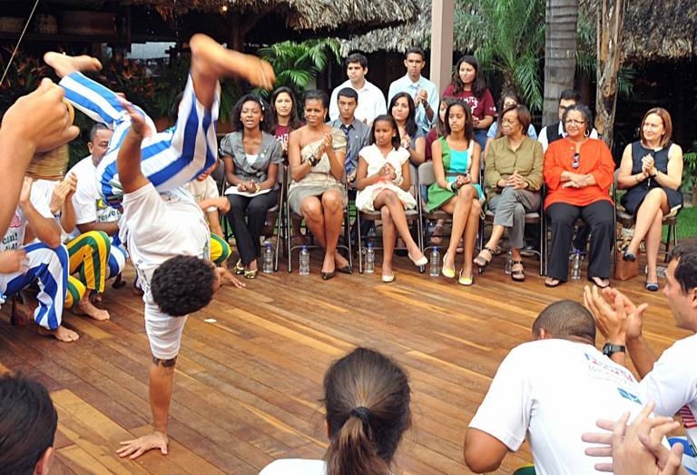 Michelle Obama, acompanhada das filhas Sasha e Malia, assiste a apresentação de capoeira