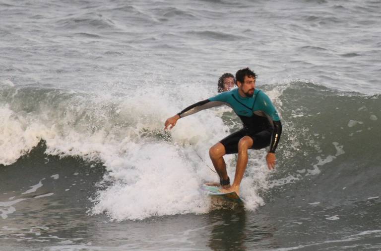 Cauã Reymond surfa em praia no Rio de Janeiro