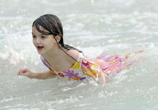 Suri Cruise e Katie Holmes brincam na praia