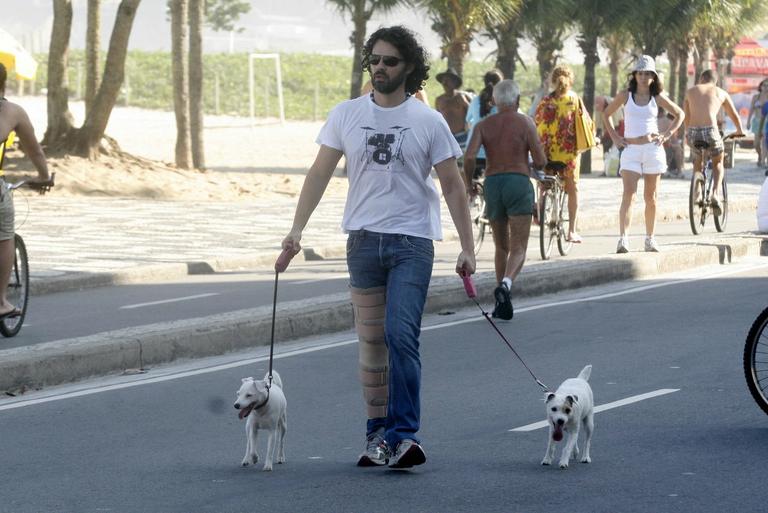 Carmo Dalla Vecchia caminha pela orla do Leblon, no Rio, com seus cachorrinhos