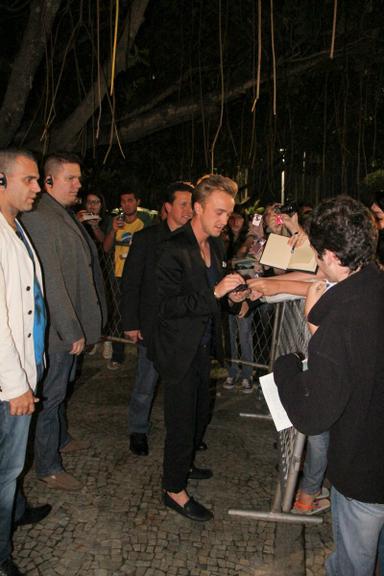 Tom Felton atende os fãs na frente do hotel, em Copacabana