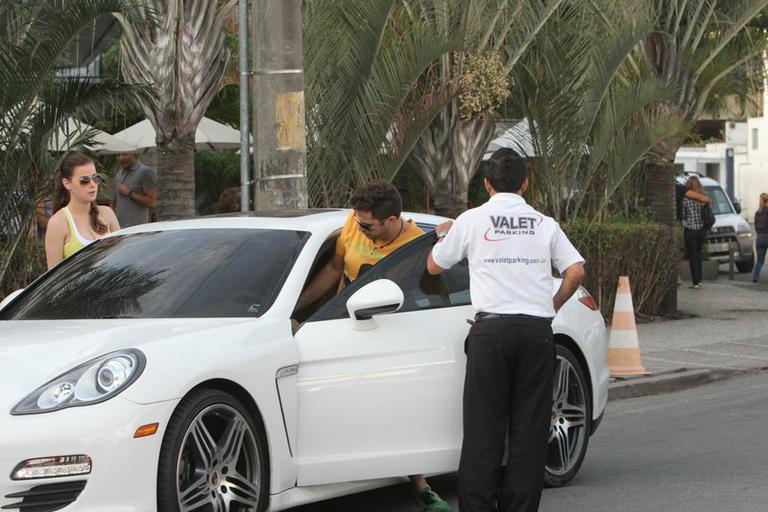 Latino e a namorada entram no Porsche do cantor, no Rio de Janeiro