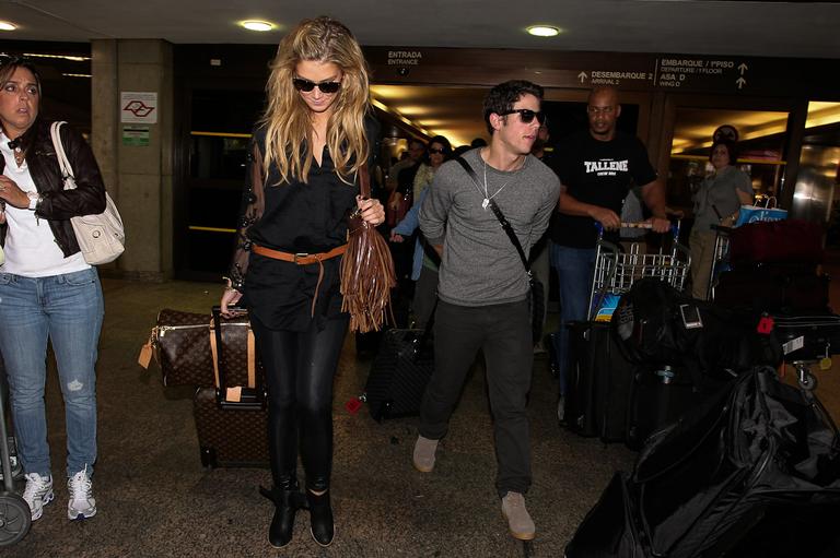 Nick Jonas desembarca no aeroporto com a namorada, a cantora Delta Goodrem