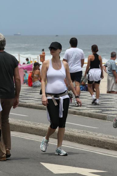 Grávida, Lavínia Vlasak caminha pela orla da praia do Leblon, no Rio de Janeiro