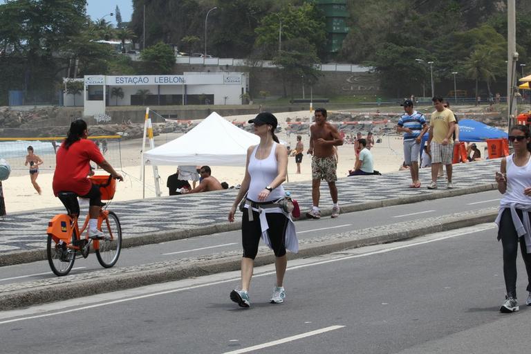 Grávida, Lavínia Vlasak caminha pela orla da praia do Leblon, no Rio de Janeiro